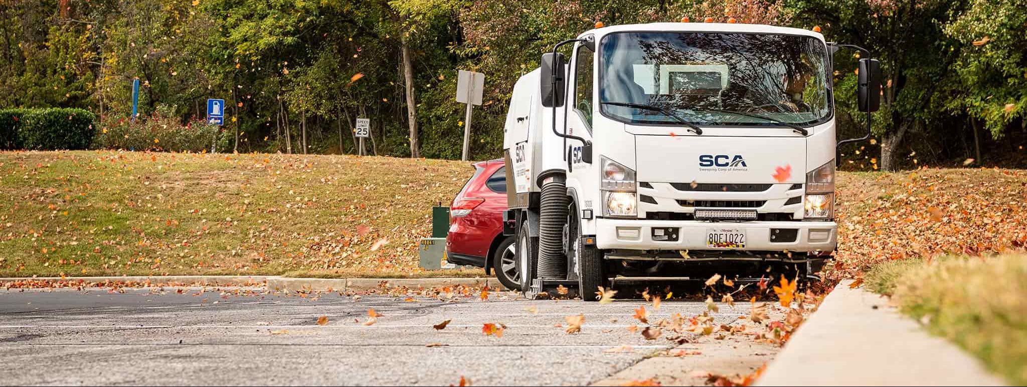 A street sweeper cleaning a parking lot