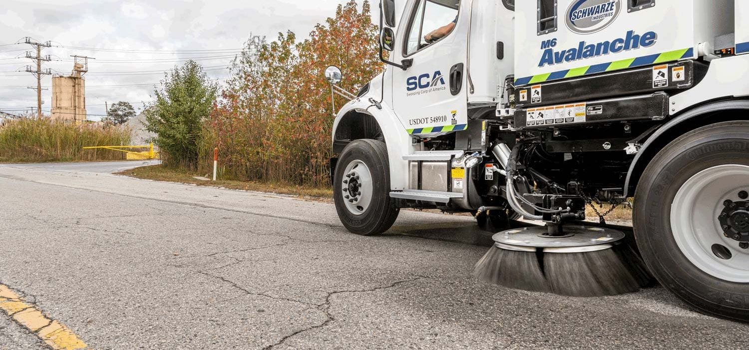 A sweeping truck cleaning a street