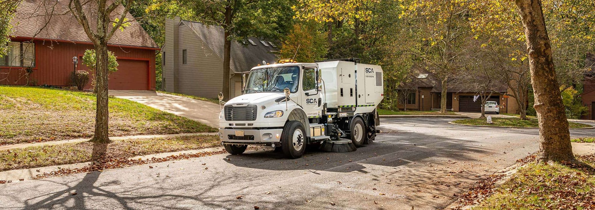 A sweeping truck cleaning a residential neighborhood