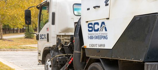 A sweeping truck cleaning a parking lot